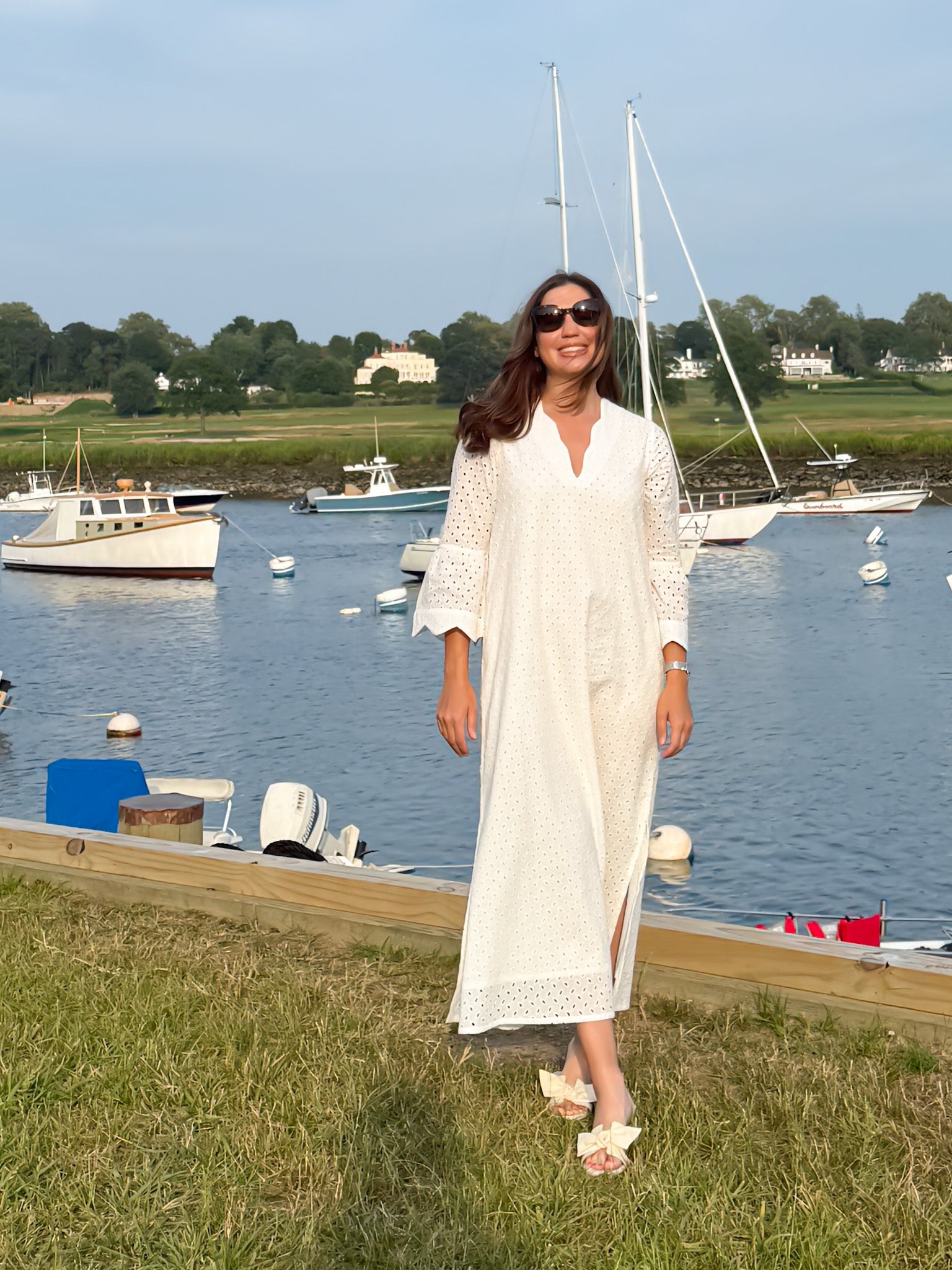 a Harbor view shot of The Amy Caftan by Sara Khatib Design showing the scallop trim neckline maxi length and bell sleeves of an off white women's caftan with open side slits